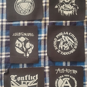May include: Six black fabric patches with white designs. The patches feature band names and logos, including "Antischism", "Conflict", "Noise Philia Cluster", and "Aus-Rotten".