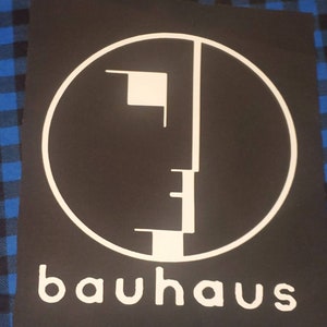 May include: Black and white Bauhaus logo with a circle and a stylized face design. The text "bauhaus" is below the logo.