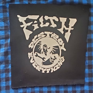 May include: Black patch with white text and graphic. The text reads "F.I.S.T.H. DESTROY EVERYTHING". The graphic is a circle with a winged figure holding a wrench and a megaphone.