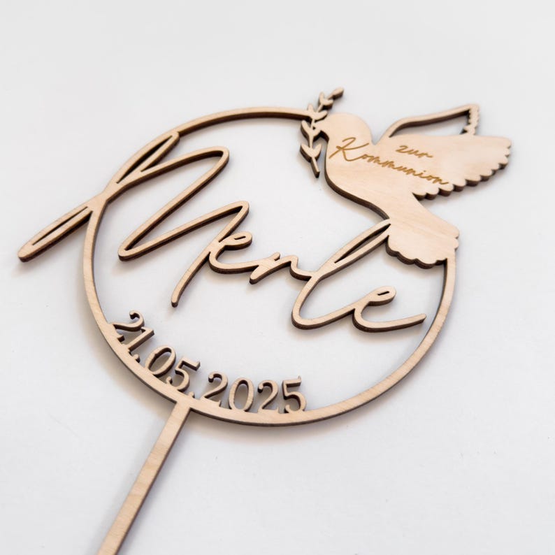 Tortenstecker zur Taufe, Kommunion oder Konfirmation mit persönlicher Gravur: Ein einzigartiges Andenken für christliche Feiern! Der aus Holz gefertigte Cake Topper mit filigraner Taube verleiht der Festtagstorte eine besondere Note. Nachhaltig & individuell personalisierbar.