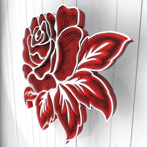 May include: A red and white layered paper rose with a 3D effect. The rose is made of multiple layers of paper, creating a dimensional look.