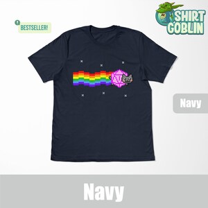 May include: A navy blue t-shirt with a pixelated cat chasing a rainbow and a pink d20 die. The text "BESTSELLER!" is in the top left corner. The text "Navy" is in the bottom right corner.