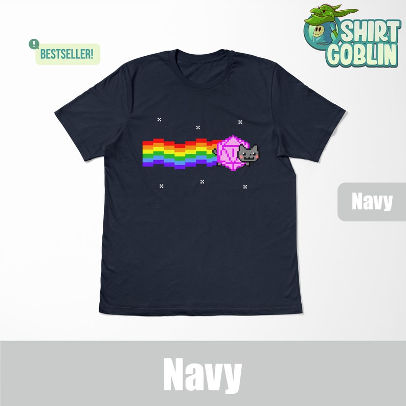 May include: A navy blue t-shirt with a pixelated cat chasing a rainbow and a pink d20 die. The text "BESTSELLER!" is in the top left corner. The text "Navy" is in the bottom right corner.