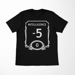 Op de afbeelding: Zwart T-shirt met een witte afbeelding van een spelkarakter statistiekblok. Het statistiekblok luidt "Intelligence -5" met een nul in een cirkel.