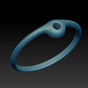 May include: A simple, silver-toned ring with a small, round hole in the top. The ring is smooth and has a polished finish.