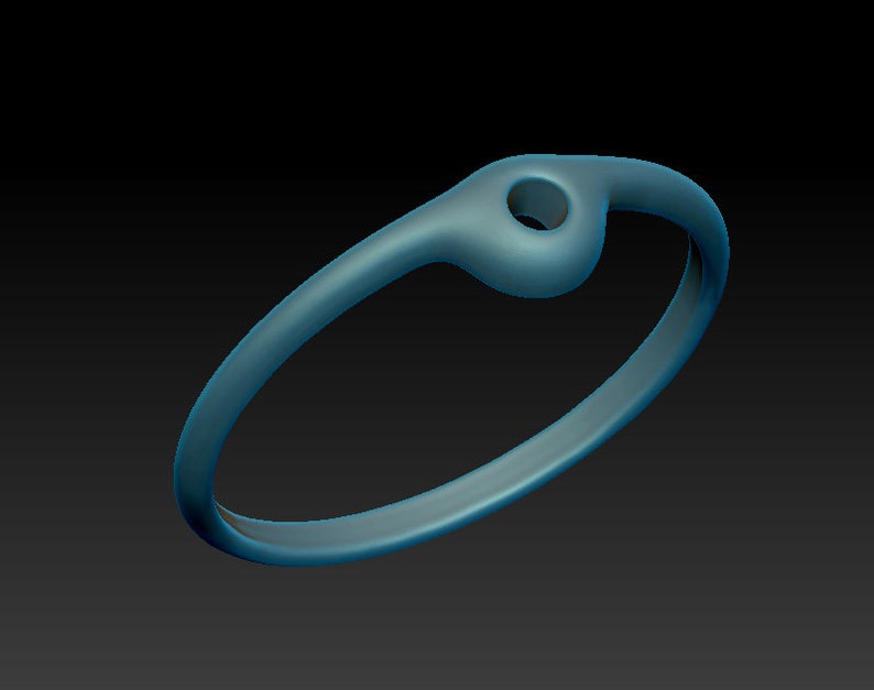 May include: A simple, silver-toned ring with a small, round hole in the top. The ring is smooth and has a polished finish.