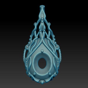 May include: A teal blue pendant with a detailed, intricate design resembling a stylized tree or plant. The pendant has a circular opening in the center and a loop at the top for hanging.