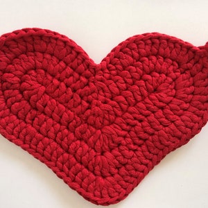 May include: Red crocheted heart-shaped hot pad with a loop handle.
