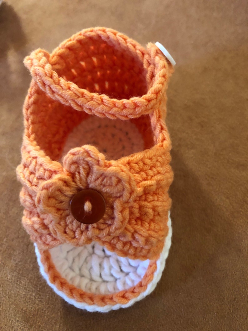 Super cute baby sandals in different designs. In orange, crocheted with flower or in pink with heart button made of cool soft cotton. image 2