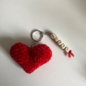 May include: Red heart-shaped plush keychain with a silver key ring and a beaded charm that spells "MUTTI".