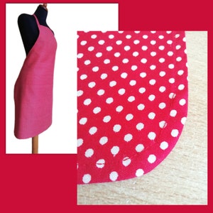 A red and white polka dot apron with a neck strap and a photo of rounded corner hem.
