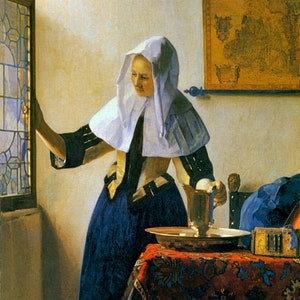 May include: A woman wearing a white cap and a blue dress pours water from a silver jug into a silver bowl on a red and blue patterned tablecloth.