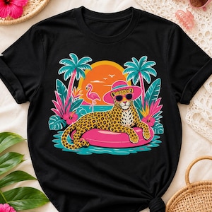 Peut inclure: T-shirt noir avec un léopard portant des lunettes de soleil et un chapeau rose, flottant sur un anneau gonflable rose. Le motif comprend des palmiers, un coucher de soleil et un flamant rose, sur le thème des vacances tropicales.