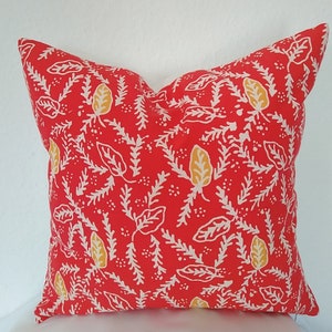 Pu&ograve; includere: Cuscino rosso con un motivo floreale bianco e giallo.