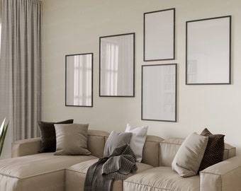 May include: A living room with a beige sectional sofa with pillows and a throw blanket. There are four black framed pictures on the wall above the sofa.