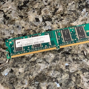 May include: A green computer memory stick with a silver key ring attached. The memory stick has the text "VIAUDIO1684D DDR3L PC3L-12800U-9-10-F3-9  1.35V 2Rx8  1024MB 300M  9997079  CL9-9-9-24" printed on it.