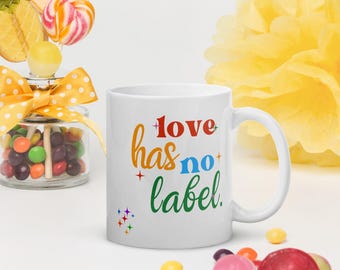 May include: White ceramic mug with a rainbow-colored design that says "love has no label".