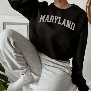 Sudadera unisex de cuello redondo negra de Maryland para hombre y mujer
