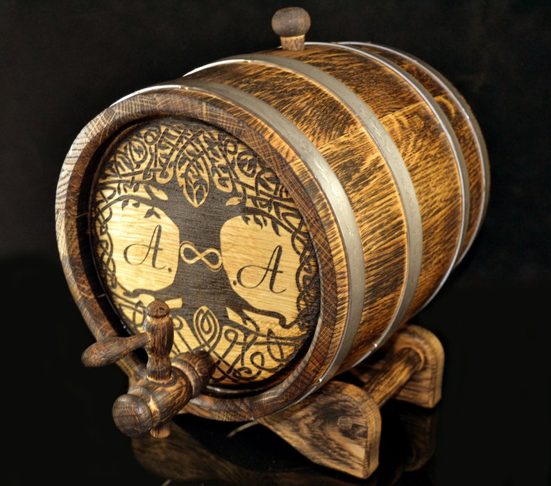 May include: A wooden barrel with a tree of life design and the initials "A. &infin; A." engraved on the front. The barrel has a metal tap and sits on a wooden stand.