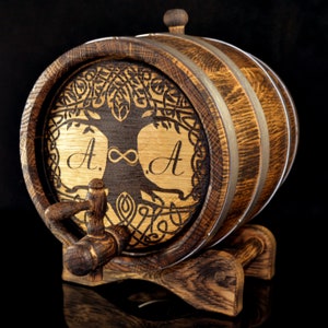 May include: A wooden barrel with a Celtic knot design and the initials "A.&infin;A" engraved on the front. The barrel has a metal tap and sits on a wooden stand.