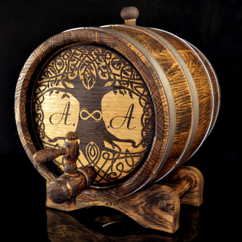 May include: A wooden barrel with a Celtic knot design and the initials "A.&infin;A" engraved on the front. The barrel has a metal tap and sits on a wooden stand.