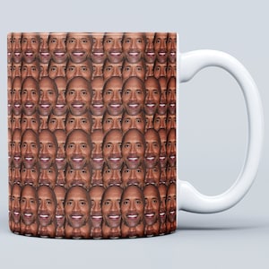 Può includere: Tazza in ceramica bianca con un motivo ripetuto di un viso maschile. L'uomo ha la pelle scura e capelli corti castani.