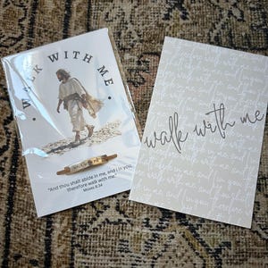 May include: Two cards and a small rolling pin with the text "Walk With Me". One card features an image of Jesus walking, with the words "Walk With Me" in a circle. The other card has the words "Walk With Me" in script.
