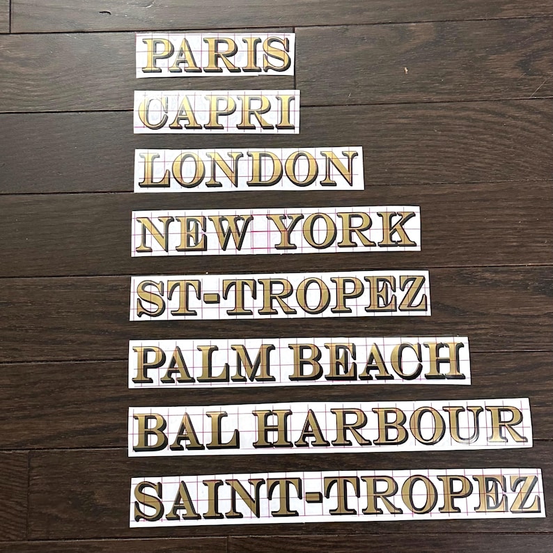 May include: Eight gold-colored vinyl stickers with the names of cities: Paris, Capri, London, New York, St-Tropez, Palm Beach, Bal Harbour, and Saint-Tropez.