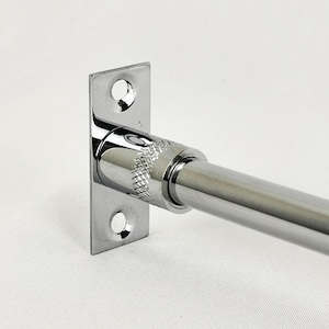 May include: A chrome-plated metal curtain rod with a square wall mount. The rod is adjustable and has a knurled knob for tightening.