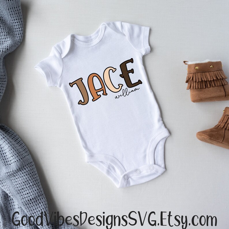 Puede incluir: Un body blanco para beb&eacute; con el nombre "Jace William" escrito en letras marrones, naranjas y beige.