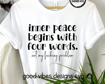 以下が含まれることがあります： 「inner peace begins with four words. not my fucking problem」という黒い文字がプリントされた白いTシャツ。Tシャツには「good vibes designs svg」という文字も黒でプリントされています。