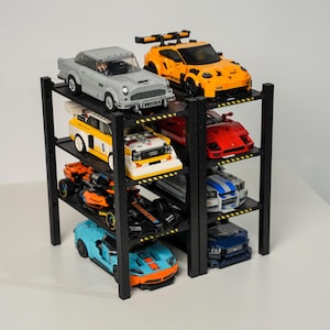 May include: A black multi-tiered shelf unit displaying a collection of toy cars. The cars are various colors, including gray, orange, yellow, red, blue, and black. The shelf unit is made of black material and has multiple levels to showcase the toy cars.