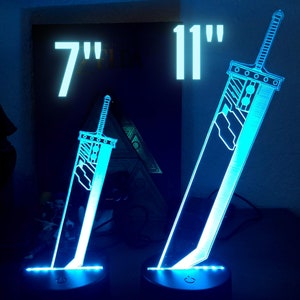 May include: Two illuminated acrylic swords, one 7 inches tall and the other 11 inches tall, with a blue glow. The swords are on black bases with a switch on the bottom.