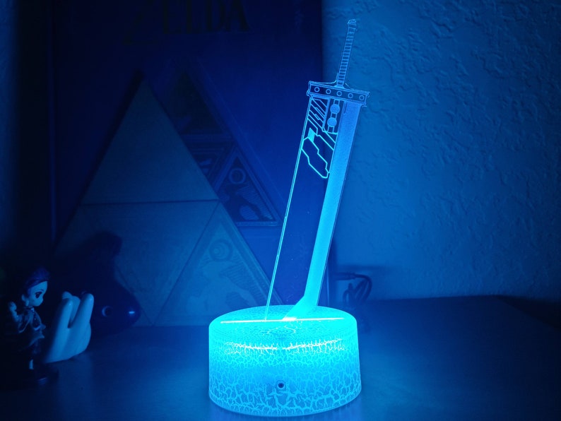 May include: A blue light-up lamp shaped like a sword with a textured base.
