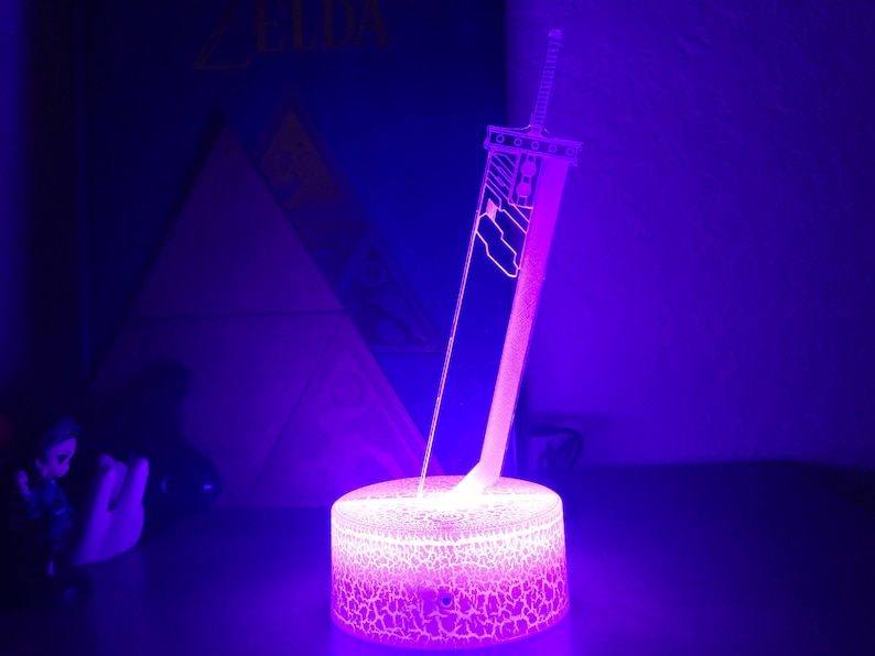 May include: A purple and white 3D printed lamp shaped like a sword. The lamp is on a textured base and is lit up.