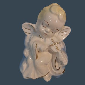 Maceta de cerámica vintage con forma de ángel tocando el violín y detalles dorados.