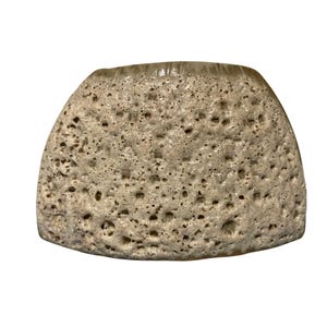 May include: A beige ceramic bowl with a highly textured, porous surface featuring numerous small indentations and craters. The vessel has a wide, rounded shape with a smooth, flat rim at the top, showcasing a natural, uneven, and pitted exterior finish.