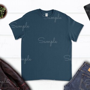 May include: A plain dark blue t-shirt on a white wood background. The t-shirt is a blank canvas for customization.