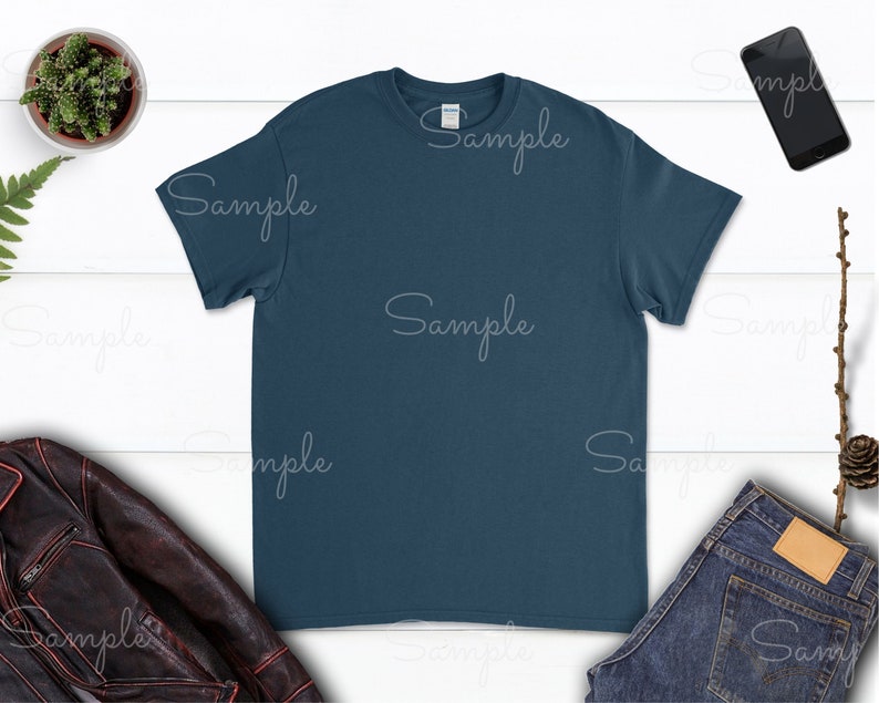 May include: A plain dark blue t-shirt on a white wood background. The t-shirt is a blank canvas for customization.