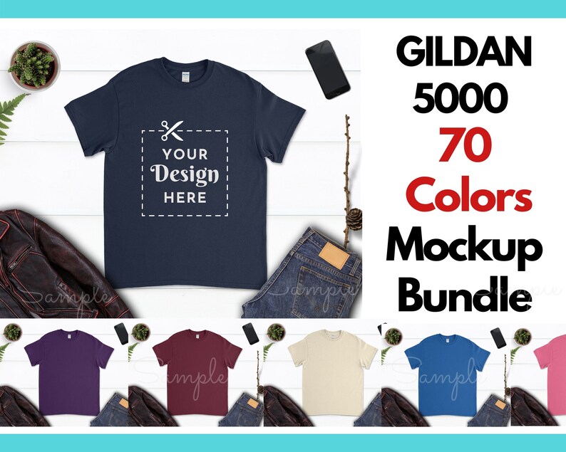 May include: A mockup bundle of 70 different colored Gildan 5000 t-shirts. The t-shirts are laid out on a white wooden surface with jeans, a phone, and a plant. The text "YOUR DESIGN HERE" is on the front of the navy blue t-shirt.