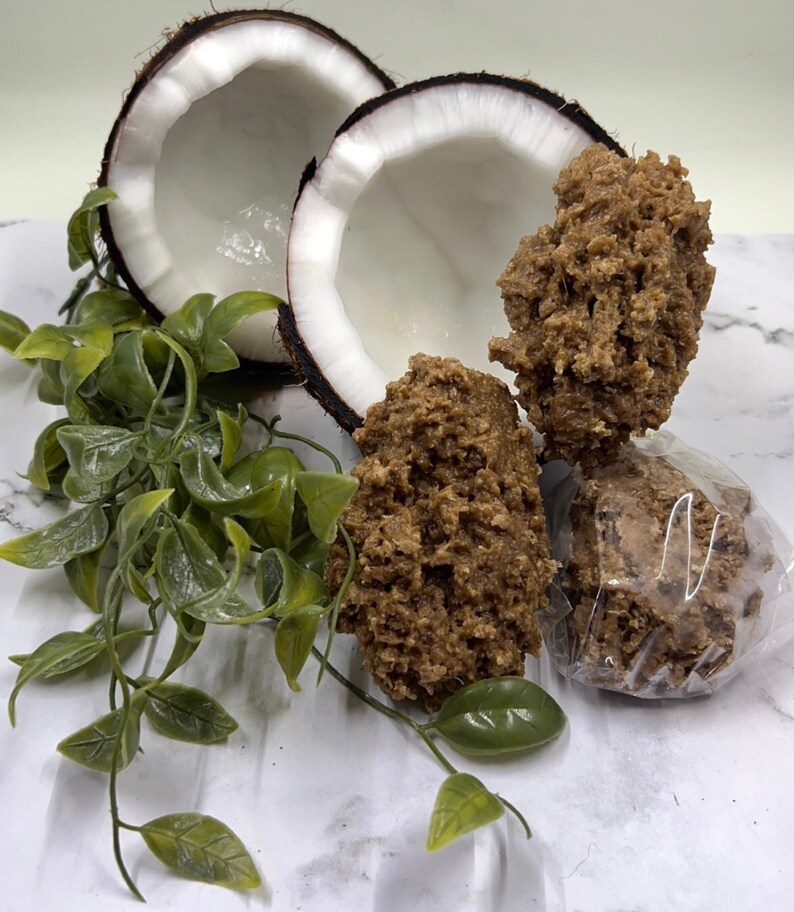 May include: Two halves of a coconut shell with brown coconut candy inside. The candy is in various shapes and sizes, some are wrapped in clear plastic.