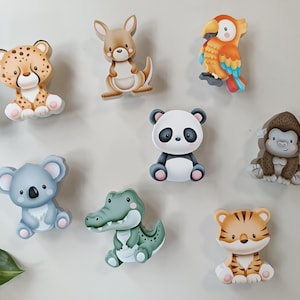 Könnte beinhalten: Eine Sammlung von acht tierförmigen Holzausschnitten, die einen Leoparden, ein Känguru, einen Papagei, einen Panda, einen Gorilla, einen Koala, ein Krokodil und einen Tiger darstellen. Jede Figur zeigt eine cartoonartige Illustration.