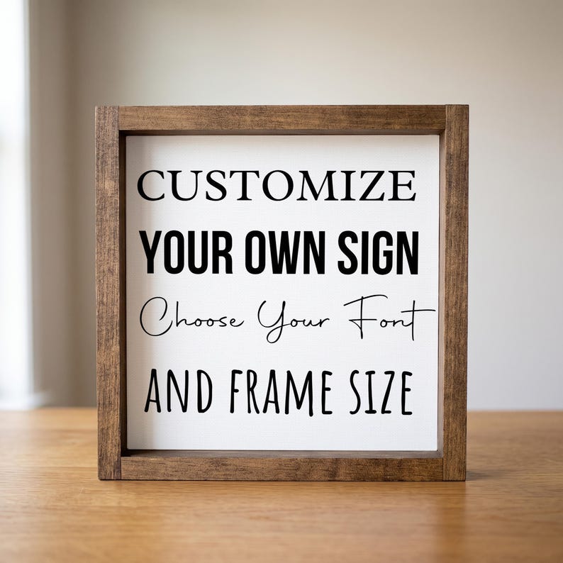 Custom quote sign in a brown wood frame on a wooden table. Black lettering on white reads 'Customize your own sign. Choose your font and frame size.'