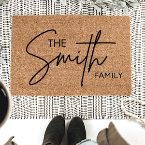 May include: A brown coir doormat with the text "The Smith Family" in black cursive lettering.