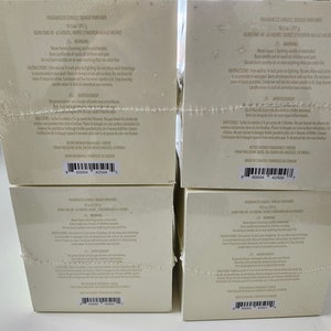 K&ouml;nnte beinhalten: Vier wei&szlig;e Boxen mit schwarzem Text und Barcodes. Die Boxen sind mit "Fragrance Candle, Bougie Parfum&eacute;e, Duftkerze, Vela Aromatica" beschriftet. Der Text auf den Boxen enth&auml;lt Informationen &uuml;ber die Kerze, wie z. B. die Brenndauer, den Duft und das Gewicht. Die Boxen sind &uuml;bereinander gestapelt.