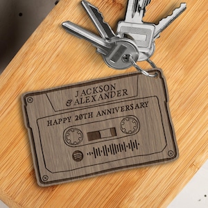May include: A wooden cassette tape keyring with the text "JACKSON & ALEXANDER HAPPY 20TH ANNIVERSARY" and a stylised cassette tape design.