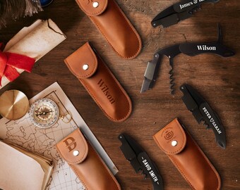 Puede incluir: Seis estuches de cuero personalizados con abridores de botellas de metal negro. Los estuches son marrones y tienen diferentes nombres grabados, incluyendo "James & Katie", "Wilson", "Peter & Sarah" y "David Smith".