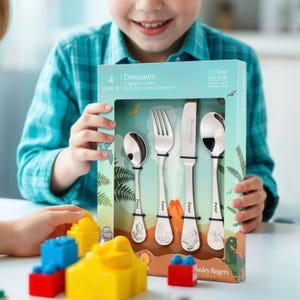 May include: A 4-piece dinosaur-themed children's cutlery set in a blue and green box. The set includes a knife, fork, spoon, and teaspoon. The cutlery is made of stainless steel and has a 10-year guarantee.