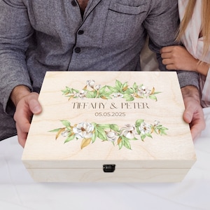May include: A wooden box with a floral design and the text "Tiffany & Peter 05.05.2025" on the lid.