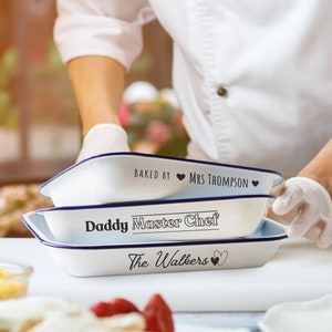 May include: Three white baking dishes with blue rims. The top dish says "Baked by Mrs. Thompson". The middle dish says "Daddy Master Chef". The bottom dish says "The Walkers".